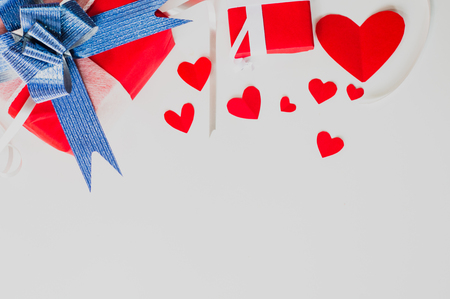 Top view Valentine day set of gift red boxes,with blue bow and ribbon, with paper heart shape,on white background,concept Celebrating festival symbolizes day of love,with copy space for text input.の写真素材