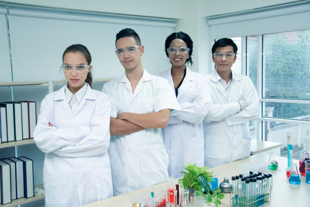 Portrait group multi-ethnic scientists standing smiling happily and cross one's arm in...