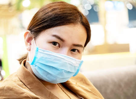 Businesswomen ceo manager company office start up freelance asian is looking at camera wear mask blue for protect covid-19 corona virus disease danger health care medicalの写真素材