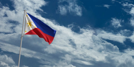 Philippines flag waving in the wind against a blue sky with white cloudsの写真素材