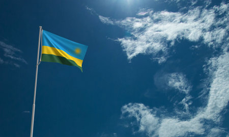 National flag of Rwanda waving in the wind against a blue sky with cloudsの写真素材