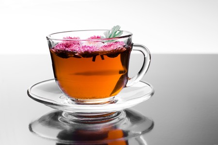 cup of herbal tea with flowers on glossy background の写真素材