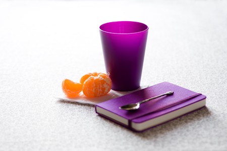 notebook, cup, tangerine and teaspoonの写真素材