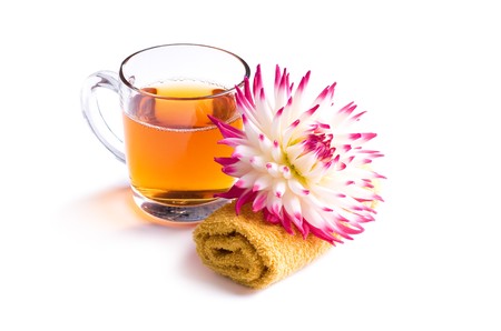 cup of herbal tea with flower on towel isolatedの写真素材