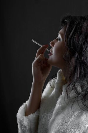 beautiful brunette girl with cigarette in handの写真素材