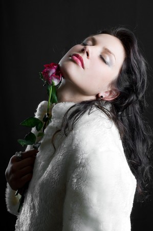 beautiful brunette girl with red rose in handの写真素材
