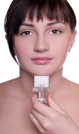 Closeup studio shot of a young beautiful woman cleaning faceの写真素材