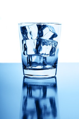 Glass with crystal clear ice cubes on glossy backgroundの写真素材