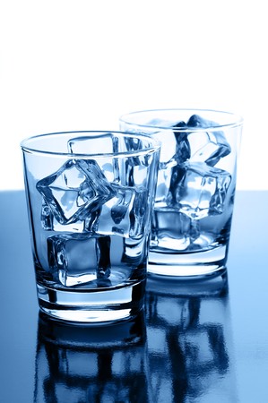 Glasses with crystal clear ice cubes on glossy backgroundの写真素材