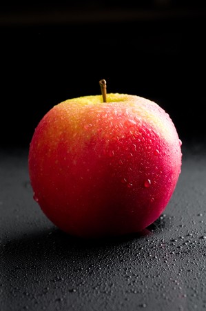 Red apple with water drops over blackの写真素材