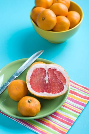 Tangerines and grapefruit on plate on tableの写真素材