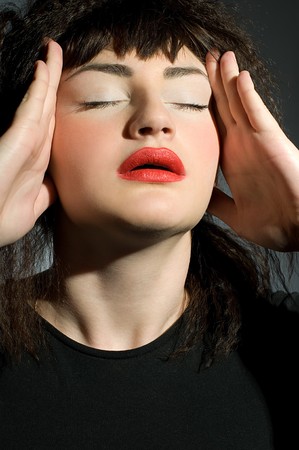 Woman with  headache holding hands to headの写真素材