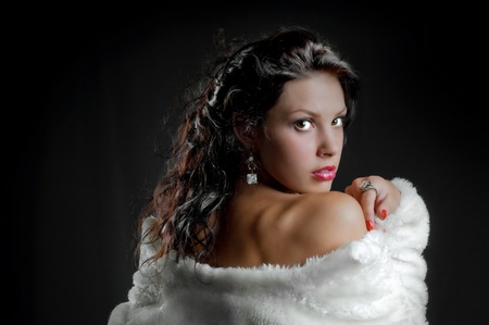 beautiful sexy girl in fur coat on blackの写真素材