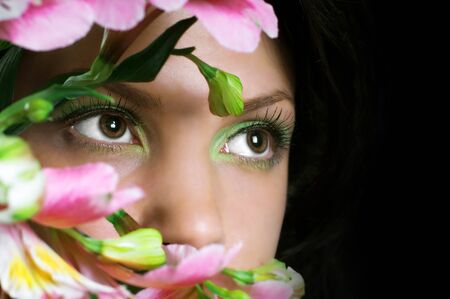 Woman with pink flowers  Focus on eyesの写真素材