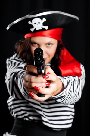 Young woman dressed as a pirate in a black hat holding an gunの写真素材