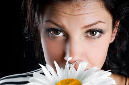 Beautiful young woman with chamomile in handの写真素材