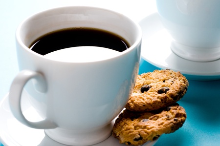 Two coffee cups with cookies on blue backgroundの写真素材