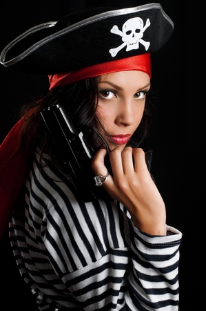 Young woman dressed as a pirate in a black hat holding an gunの写真素材