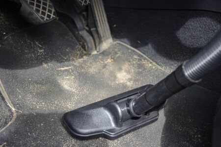 Cleaning dirt in a car with a vacuum cleaner.の写真素材