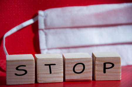 Hygienic face mask against the virus. Stop written on a wooden block. Outbreak Prevention Concept.の写真素材