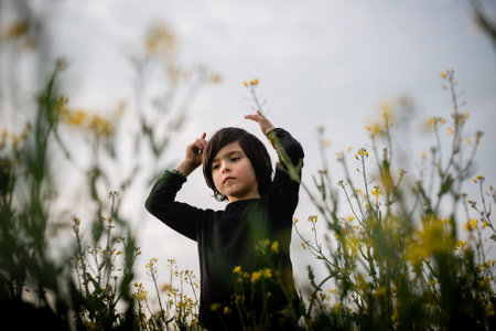 Portrait of a young girl in a field of yellow flowers.の写真素材