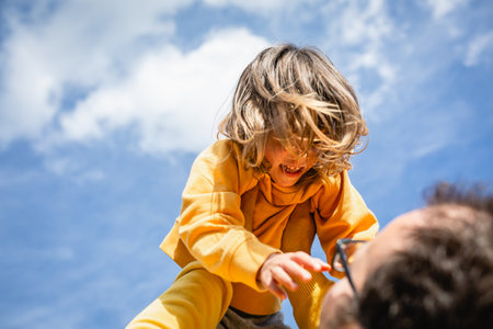 Father and son having fun outdoors on sunny day. Concept of friendly family.の写真素材