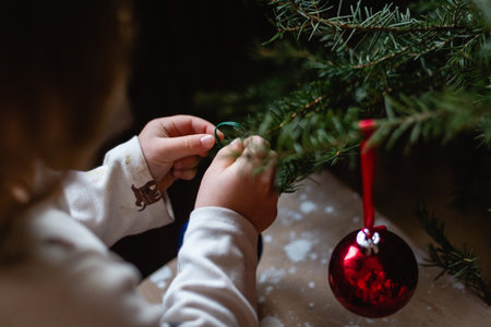 Children hands decorating Christmas tree at homeの写真素材