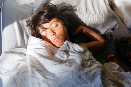 upper view on sleeping girls face in the morning lightの写真素材