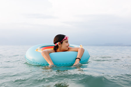 girl taking rest in the water inside swiming ringの写真素材