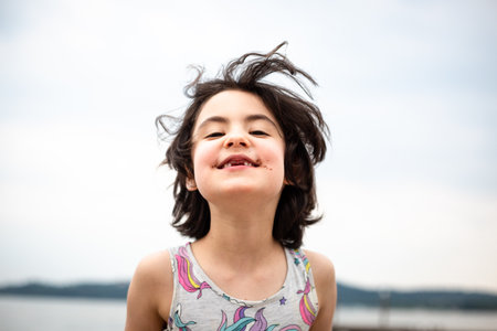 portrait of smiling girl with dark short hair and thoothless smile