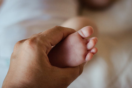 hand of mother holding foot of newborn