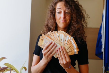 woman watching at the money she is holding in both hands