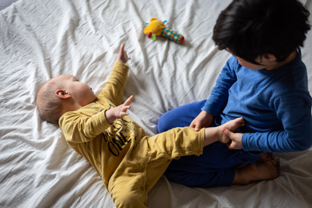 upper view on two children playing on the bedの写真素材