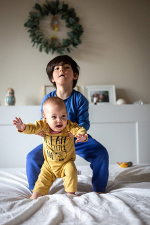 bigger child taking up smaller baby in the bedroom