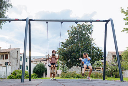 mother with two daughters in children playground