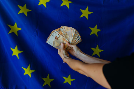 hands holding pack of money against european union flagの写真素材