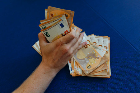 close-up view of man hand holding a pile of money