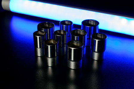 Socket wrench heads made of chrome vanadium on the dark background in a neon blue light.