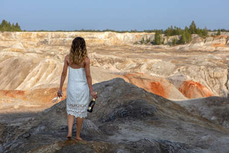 A girl with glasses and champagne is walking along.Top view of the quarryの写真素材