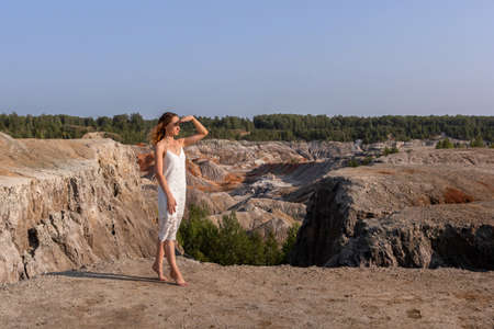 A beautiful woman on the background of landscape.Top view of the quarry.の写真素材