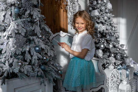 The girl is preparing for the new year, decorating the Christmas treeの写真素材