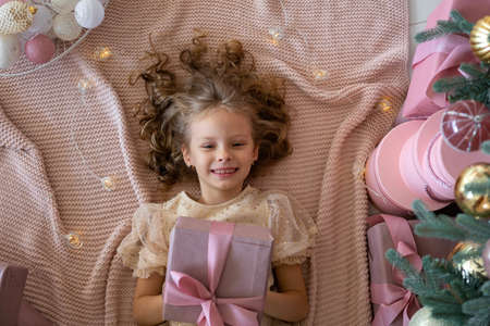 Top view of a lying girl in a beautiful dress.The girl has a gift in her handsの写真素材