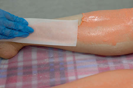 The master removes the wax with the help of special bandage stripsの写真素材