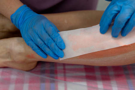 The master removes the wax with the help of special bandage stripsの写真素材