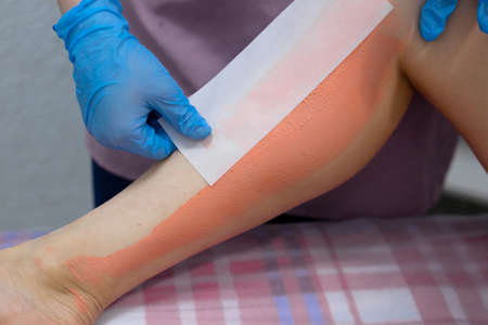 The master removes the wax with the help of special bandage stripsの写真素材