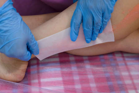 The master removes the wax with the help of special bandage stripsの写真素材