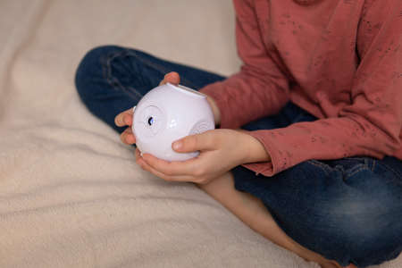 The girl is holding a small multimedia projector in her hands.の写真素材