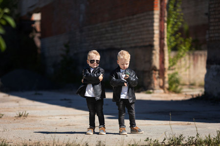 Blond twin boys in dark glasses and leather jackets.The little twinsの写真素材