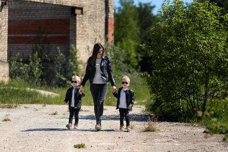 Mom goes by the hand with her sons.Mother and twinsの写真素材