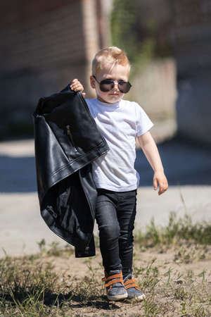 A blond guy with dark glasses and a leather jacket.の写真素材